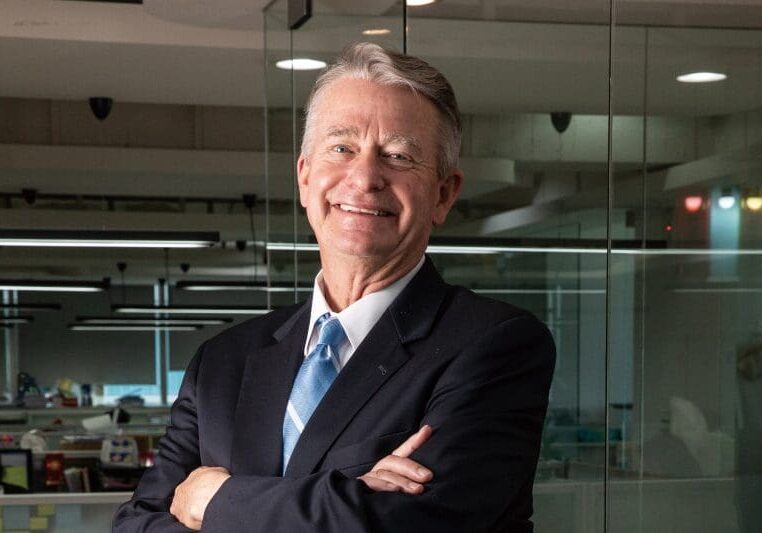 A man in a suit and tie standing in an office.